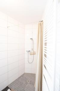 ein weißes Bad mit Dusche und Duschvorhang in der Unterkunft -Super zentrales Zimmer- direkt an der Lutter! in Bielefeld