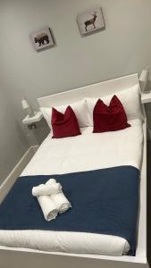 a bed with red and white pillows on it at Brilliant 2 Bed Apartment - 2 The Southwell in London