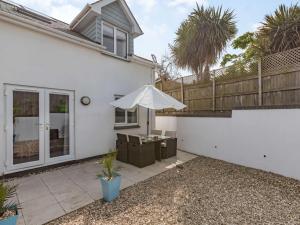 a white house with an umbrella and a patio at 2 Bed in Westward Ho 73566 in Westward Ho