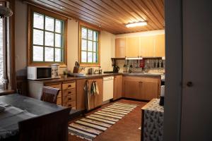a large kitchen with wooden cabinets and a table at Bed & Breakfast Willa Armas in Övertorneå