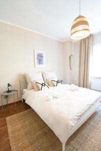 a large white bed in a bedroom with a pendant at -Super zentrales Zimmer- direkt an der Lutter! in Bielefeld