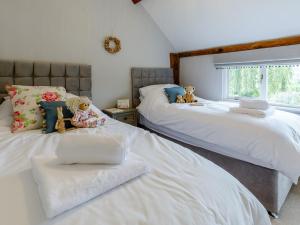 two beds with teddy bears sitting on them in a bedroom at 3 Bed in Presteigne 78350 in Kinsham