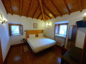 a bedroom with a white bed and two windows at Hotel Sintra Jardim in Sintra