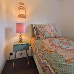 a bedroom with a bed and a table with a lamp at Bungalow AMNIS in Lanaken