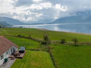 a house in a field with a view of a lake at 3 bed property in Onich CA159 in Onich