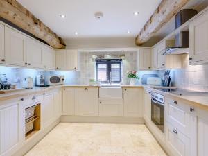a kitchen with white cabinets and a window at 3 bed in Winterton-on-Sea 77582 in Hickling