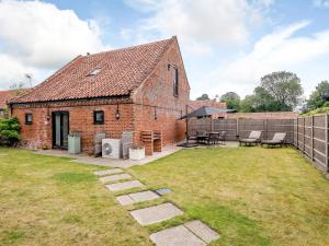 a brick building with a patio and a yard at 3 bed in Winterton-on-Sea 77582 in Hickling