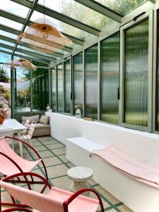 a conservatory with pink chairs and tables and windows at MaïHomes - La Villa Marseillaise in Marseille