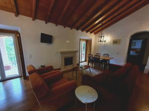 a living room with couches and a table and a fireplace at Hotel Sintra Jardim in Sintra
