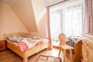 a bedroom with a bed and a window at Apartamenty u Gabi in Poronin