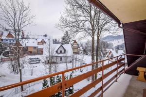 a balcony with a view of a snow covered village at Apartamenty u Gabi in Poronin