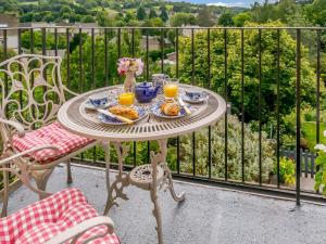 a table with food and orange juice on a balcony at 3 Bed in Nailsworth 78968 in Nailsworth