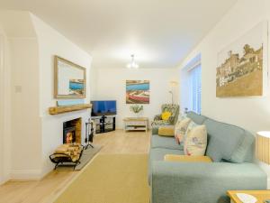 a living room with a blue couch and a fireplace at 2 Bed in Lulworth Cove DC028 in West Lulworth