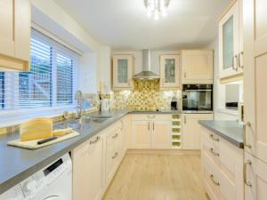 una cocina con armarios blancos y fregadero en 2 Bed in Lulworth Cove DC028, en West Lulworth