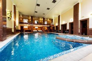 a large swimming pool with blue water in a building at PARKOVY apart in Truskavets