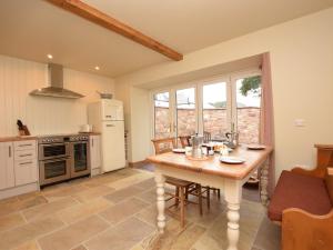 a kitchen with a wooden table with chairs and a table sidx sidx sidx at 2 Bed in Peebles 76383 in West Linton
