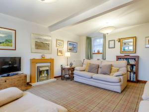 a living room with a couch and a fireplace at 2 Bed in Crail CA006 in Crail