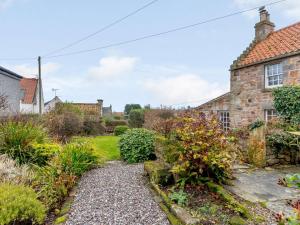 a garden in front of a stone house at 2 Bed in Crail CA006 in Crail