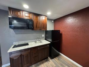 uma cozinha com um lavatório e um frigorífico preto em Residency Inn & Studios em Waynesburg
