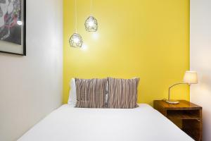 una camera con un letto bianco e una parete gialla di WHome Central Alfama Hideaway perfect to explore Lisbon a Lisbona