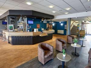 a lobby with a counter and chairs and a bar at ibis Auxerre Sud in Venoy