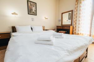 1 dormitorio con 2 camas, sábanas blancas y toallas en Mountain Hotels "Achais", en Planitéron