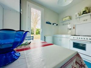 eine Küche mit einem blauen Stuhl auf einem Tisch in der Unterkunft Maison de famille au calme quartier de la Marcelliere in Les Sables-dʼOlonne