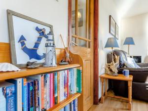 una sala de estar con una estantería llena de libros en 1 bed property in Badachro CA085, en Strath