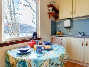 a table with a plate of food on it in a kitchen at 1 bed property in Badachro CA085 in Strath
