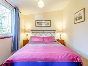 a bedroom with a bed with pink sheets and a window at 1 bed property in Badachro CA085 in Strath