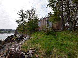 a house on the shore of a body of water at 1 bed property in Badachro CA085 in Strath