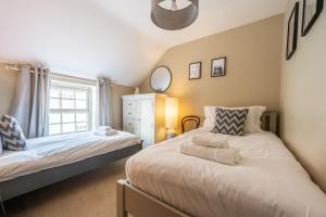 a bedroom with two beds and a window at Foxhill House in South Creake