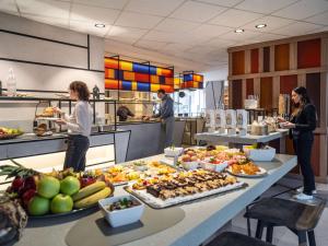 um grupo de pessoas em pé em uma cozinha preparando comida em Novotel Suites Wien City Donau em Viena