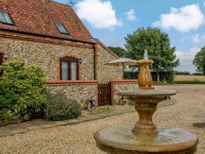 a fountain in front of a house with an umbrella at 2 bed in Tatterset 77765 in Tattersett