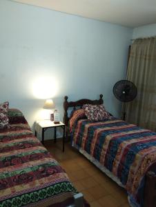 1 dormitorio con 2 camas y mesa con lámpara en Lo de Su 2 en Salta