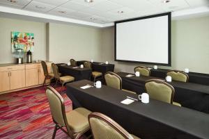 una sala de conferencias con mesas, sillas y una pantalla en Home2 Suites by Hilton San Antonio Airport, TX, en San Antonio