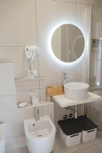 a white bathroom with a sink and a mirror at Tra Lago Maggiore e lago d'Orta Appartamento TERRA in Colazza +56 photos