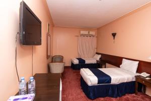 a hotel room with two beds and a flat screen tv at فندق برج العالم in Mecca