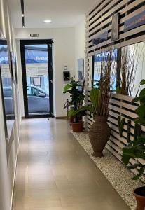 um corredor de escritório com vasos de plantas e uma porta de vidro em PURA VIDA em Arguineguín