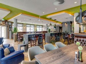 a restaurant with a table and chairs and a bar at ibis Styles Tuebingen in Tübingen