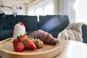 Un plato de fresas y croissants en una mesa. en Laguna Beskidów Resort - Apartament A15, en Zarzecze