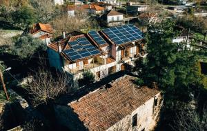an aerial view of a house with solar panels on the roofs at Mountain Hotels "Achais" in Planitéron