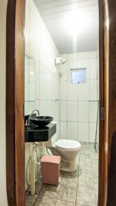 a bathroom with a toilet and a sink at Casa Flor da Serra in Nobres