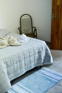 a bed with a blue blanket and a blue rug at Casa Flor da Serra in Nobres