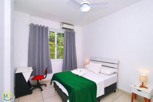 Habitación blanca con cama y ventana en Ótimo 2 quartos na quadra da praia para 6 pessoas, en Río de Janeiro