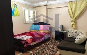 Un pequeño dormitorio con una cama y una silla. en BLUE Wave, en Alejandría