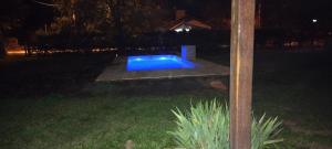 una piscina azul en un patio por la noche en A´mar en Villa General Belgrano