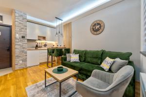 ein Wohnzimmer mit einer grünen Couch und einem Tisch in der Unterkunft Durmitor 64 - Titova vila in Zlatibor