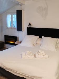 1 cama blanca con 2 toallas y chimenea en Maison SPA DISNEY, en Lagny