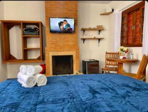 a bedroom with a blue bed with towels and a fireplace at Refugio Victoria in Monte Verde
